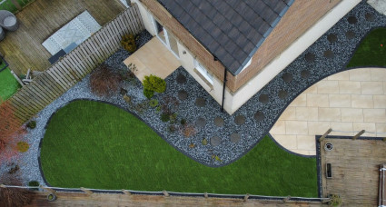 Aerial view of a landscaped garden with curved patio and lawn