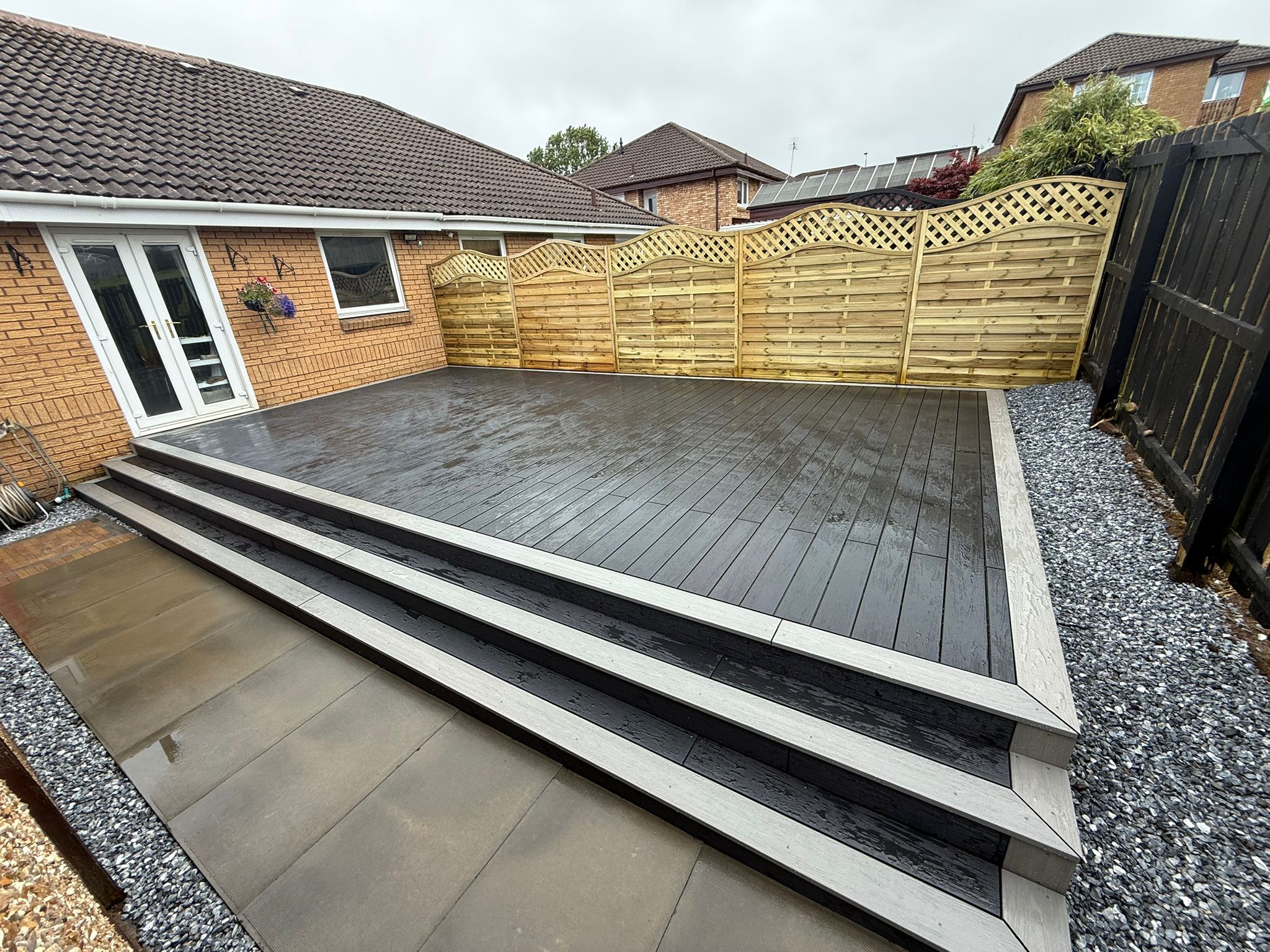 Raised composite decking in charcoal with contrasting silver edging